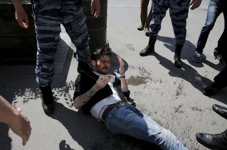 A gay rights activist lies on ground after being attacked and pepper sprayed by anti-gay protesters during an LGBT (lesbian, gay, bisexual, and transgender) community rally in central Moscow, Russia, May 30, 2015. REUTERS/Maxim Shemetov