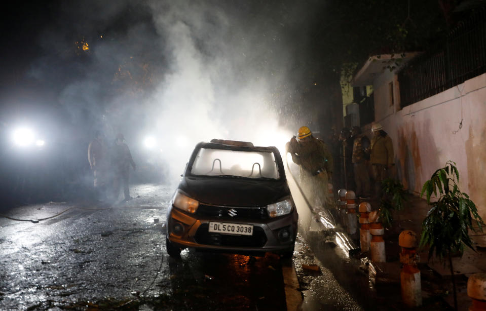 Firefighters douse a car after demonstrators set it on fire during a protest against a new citizenship law in Delhi, India, December 20, 2019. REUTERS/Adnan Abidi