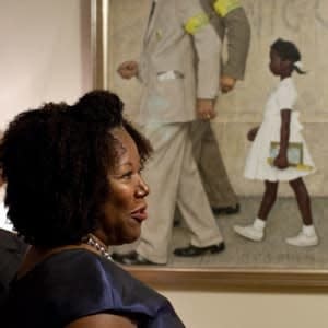 Ruby Bridges in front of a Norman Rockwell painting that depicts her being escorted into an all-white school.