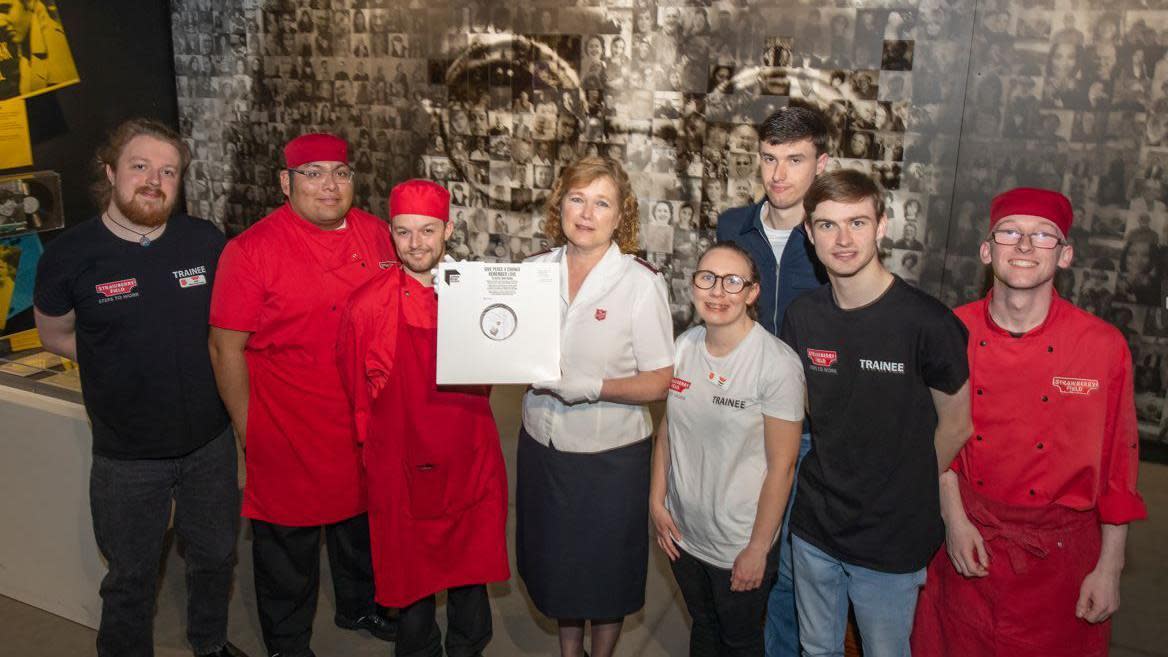 Mission Director of Strawberry Field, Major Kathy Versfeld holding the vinyl with members of the Salvation Army Steps to Work programme