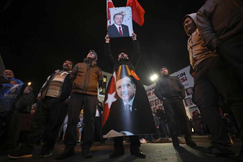 Supporters of President Recep Tayyip Erdogan holds his picture after the local elections, in Istanbul, Sunday, March 31, 2019. Erdogan's ruling party is leading in Sunday's municipal elections that he has depicted as a fight for Turkey's survival, but may lose control of the capital in the vote that is seen as a test of his support amid a sharp economic downturn. (AP Photo/Emrah Gurel)