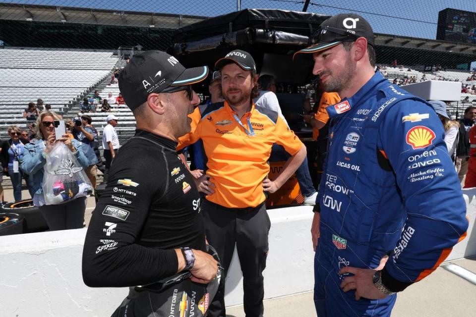 Arrow McLaren team principal Gavin Ward (center) looks on in May of 2023 as then-Indy 500 driver Tony Kanaan -- now the team's sporting director -- and full-time driver Alexander Rossi (right) talk on pitlane at the Indianapolis Motor Speedway.