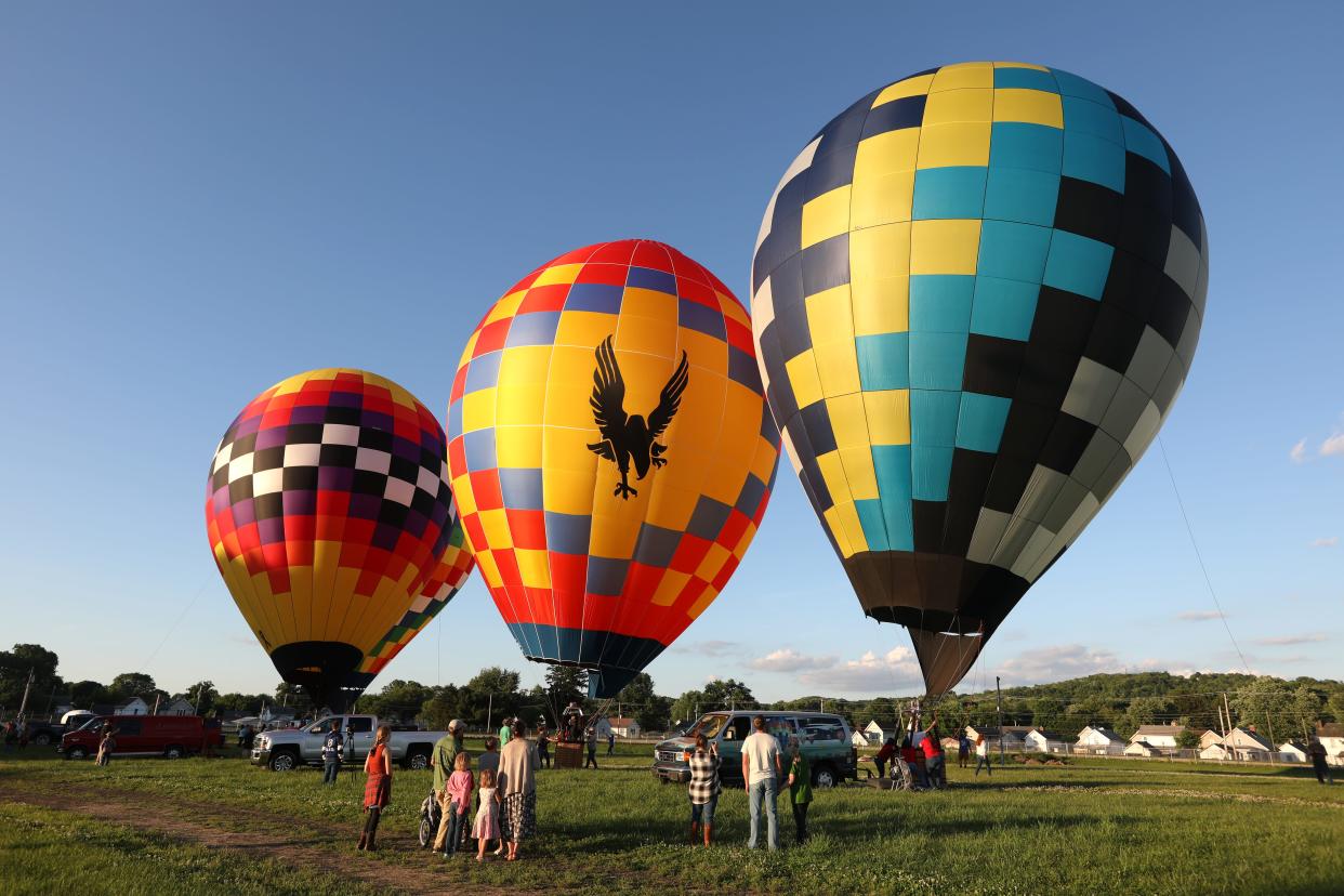 Festivalgoers watch as hot air balloons are inflated at the Coshocton County Fairgrounds.