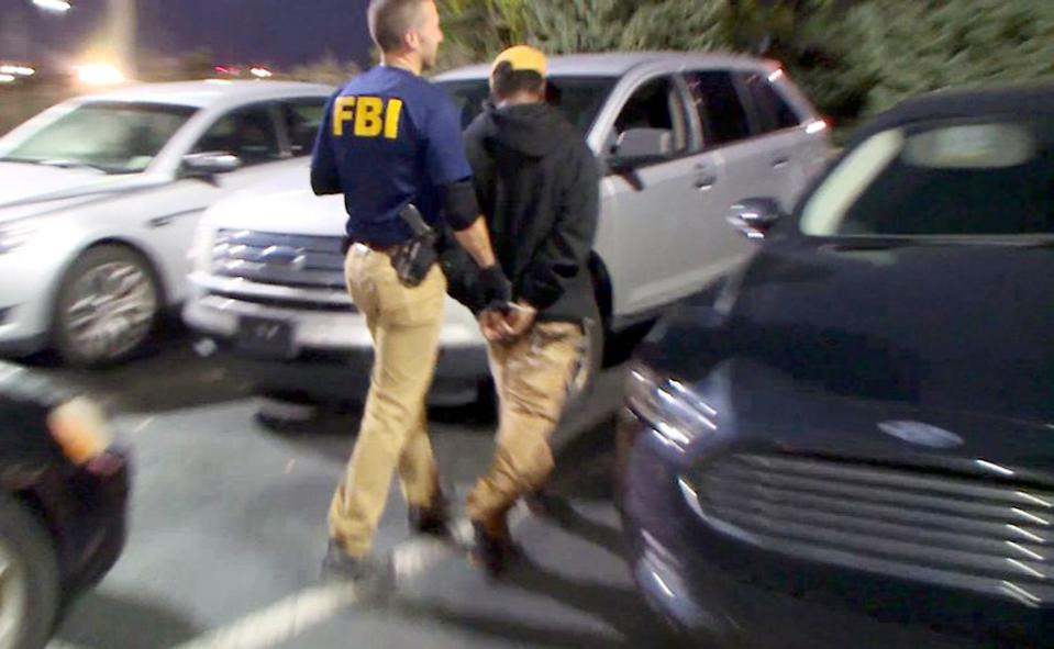 In Detroit, an FBI agent takes a suspected pimp into custody during the FBI's recent enforcement operation called Operation Cross Country. Contributed Photo