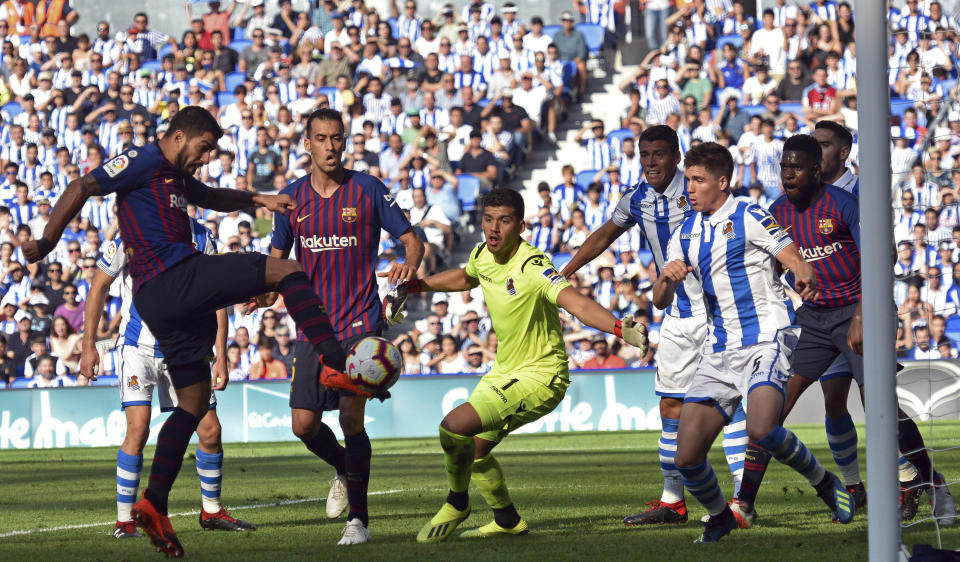 El delantero uruguayo Luis Suárez (izquierda) anota el primer gol del Barcelona en el partido contra la Real Sociedad, el sábado 15 de septiembre de 2018 en San Sebastián, España. (AP Foto/José Ignacio Unanue)