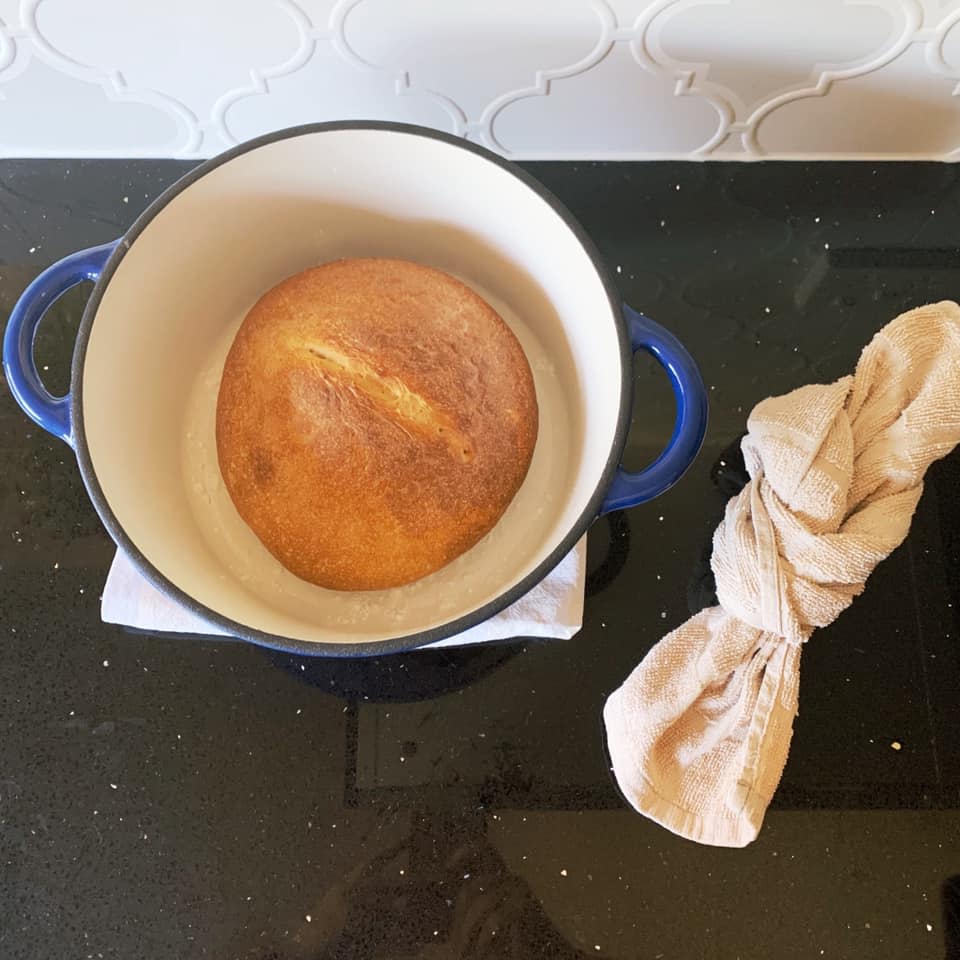 freshly baked sourdough in a blue casserole pot