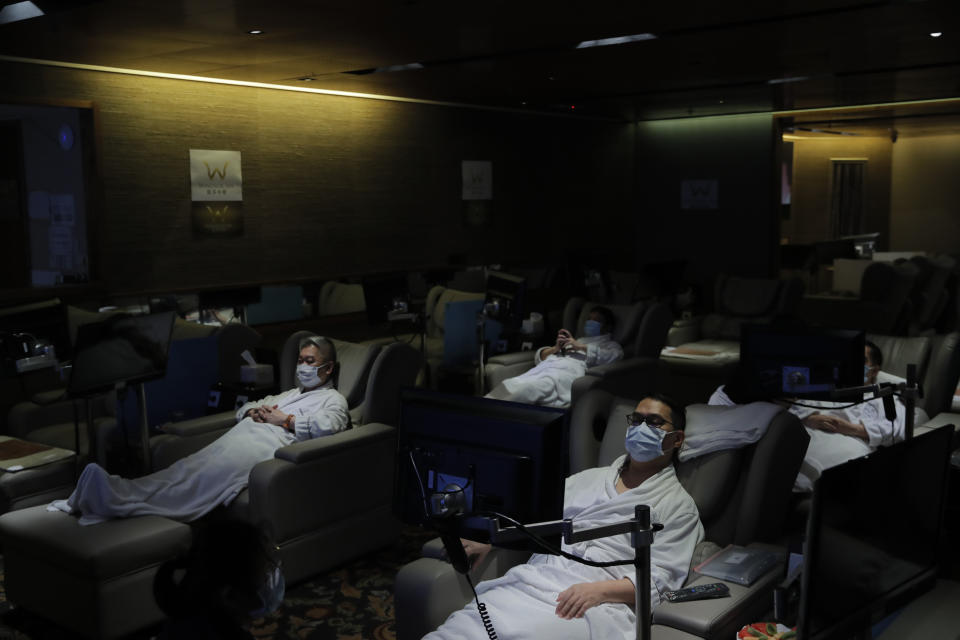 Staff members wearing face masks demonstrate the safety measures to media as the massage spa plan to be reopened in Hong Kong, Thursday, Sept. 17, 2020. Government officials said that it would further relax social-distancing measures, allowing bars, amusement parks and swimming pools to re-open. (AP Photo/Kin Cheung)