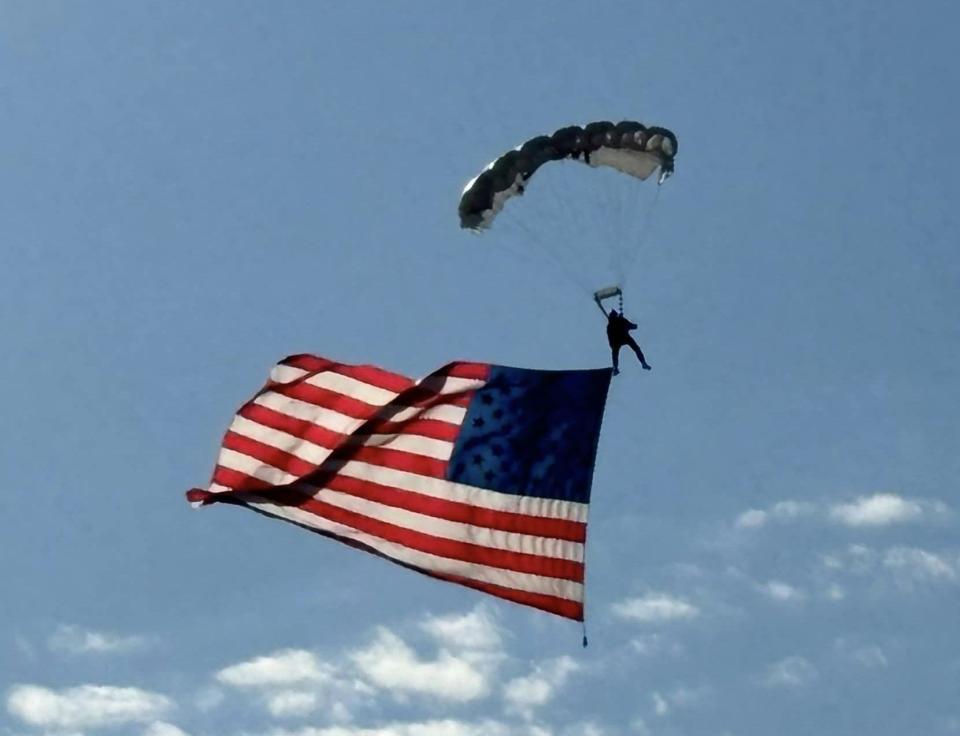 A parachutist displays a U.S. flag before the NASCAR Cook Out 400 at the Richmond Raceway on August 11, 2024.