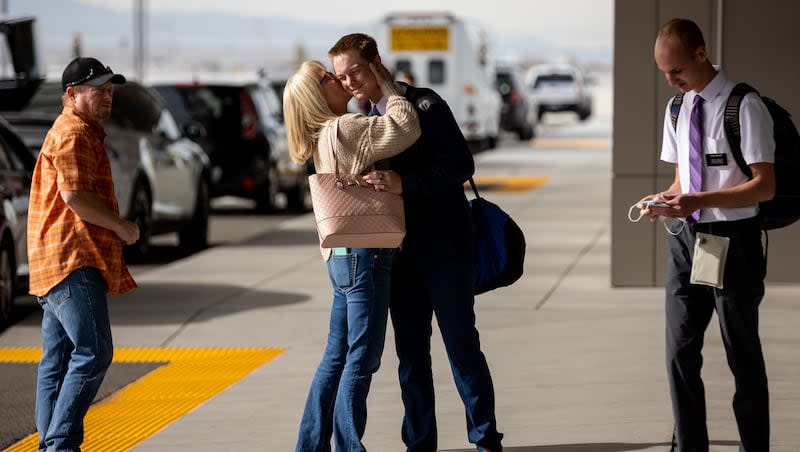 Rusty Dutson, left, watches as his wife, Margaret Dutson, bids farewell to their son, Elder Hayden Dutson, as he and Elder Jonathon Buhler, right, depart for missions for The Church of Jesus Christ of Latter-day Saints at Salt Lake City International Airport in Salt Lake City on Thursday, Nov. 18, 2021. The two missionaries are both bound for the church’s Missionary Training Center in Accra, Ghana.