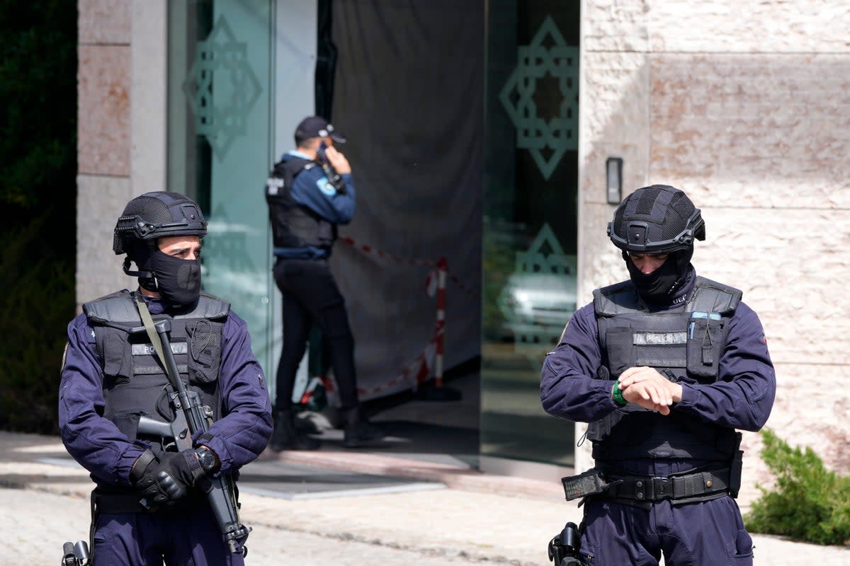Police officers stand at the entrance of an Ismaili Muslim center in Lisbon, Portugal on Tuesday (AP)