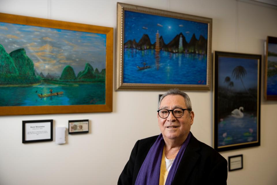 Artist Dago Benavidez in front of his work displayed at the Salem Public Library.