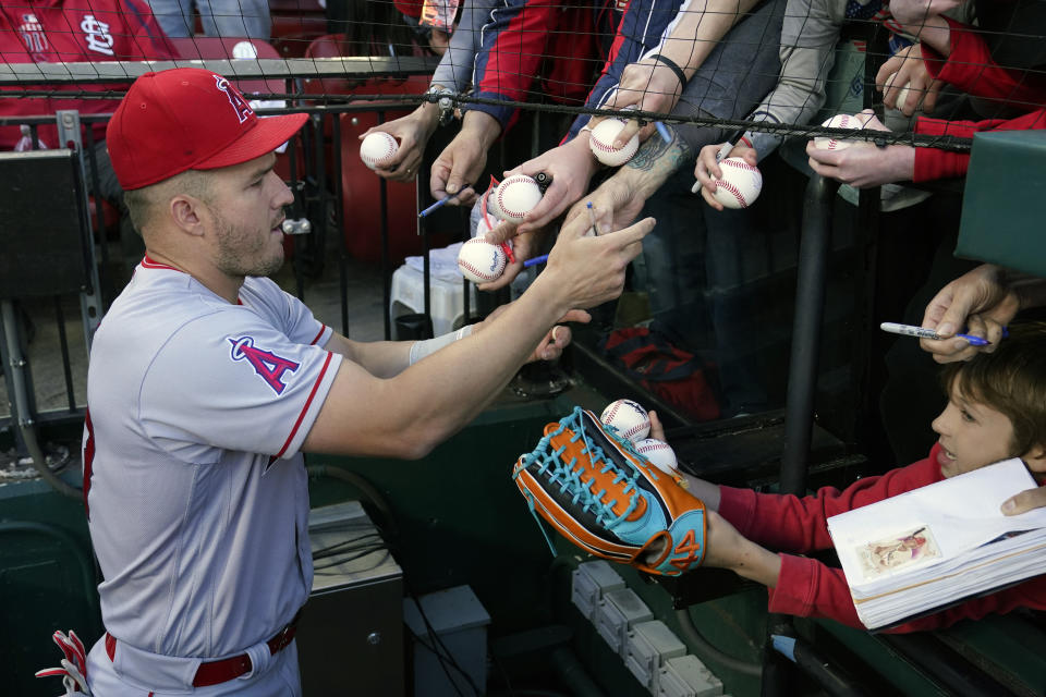 Los Angeles Angels' Mike Trout signs autographs before the start of a baseball game between the St. Louis Cardinals and the Los Angeles Angels Tuesday, May 2, 2023, in St. Louis. (AP Photo/Jeff Roberson)