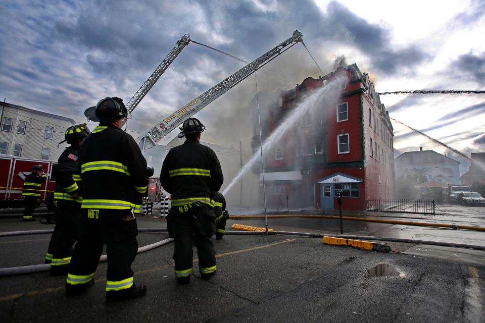 New Bedford firefighters spray water onto a rooming house on fire at 1301-1307 Acushnet Avenue Tuesday, March 28.