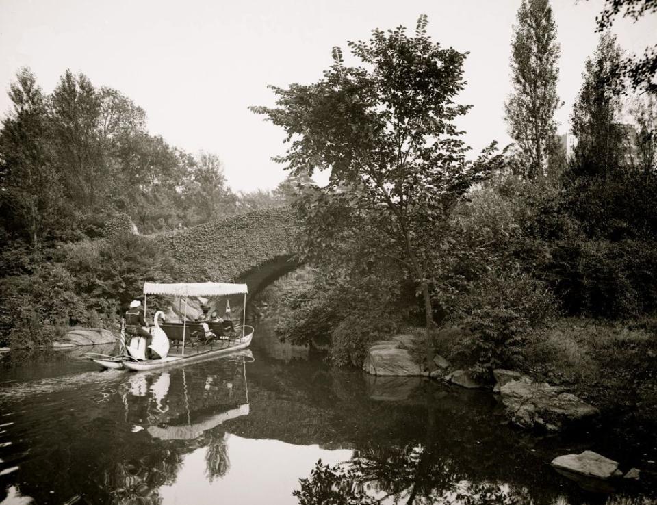 <p>Tourists take a boat ride in Central Park. The small boat is able to fit underneath the park's small arch bridges.</p>