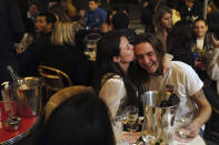 A couple kiss during a drink on the terrace of a restaurant before the nightly curfew due to the restrictions against the spread of coronavirus, in Paris, France, Friday, Oct. 23, 2020. In much of Europe, city squares and streets, be they wide, elegant boulevards like in Paris or cobblestoned alleys in Rome, serve as animated evening extensions of drawing rooms and living rooms. As Coronavirus restrictions once again put limitations on how we live and socialize, AP photographers across Europe delivered a snapshot of how Friday evening, the gateway to the weekend, looks and feels. (AP Photo/Francois Mori)