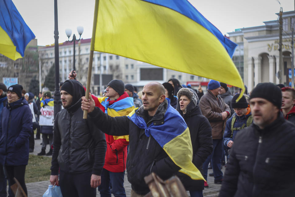 A man holds a Ukrainian flag during a rally against the Russian occupation in Svobody (Freedom) Square in Kherson, Ukraine, Wednesday, March 9, 2022. Ever since Russian forces took the southern Ukrainian city of Kherson in early March, residents sensed the occupiers had a special plan for their town. Now, amid a crescendo of warnings from Ukraine that Russia plans to stage a sham referendum to transform the territory into a pro-Moscow "people's republic," it appears locals guessed right. (AP Photo/Olexandr Chornyi)