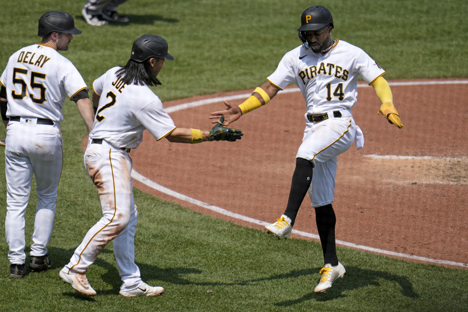 Pittsburgh Pirates' Rodolfo Castro (14) and Connor Joe (2) celebrate after scoring on a double by Tucupita Marcano off Arizona Diamondbacks starting pitcher Merrill Kelly during the fifth inning of a baseball game in Pittsburgh, Sunday, May 21, 2023. (AP Photo/Gene J. Puskar)