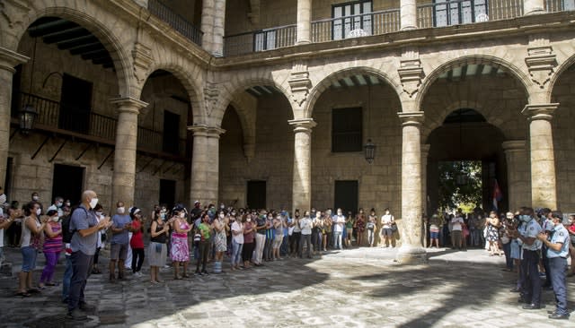 Office of the City Historian workers, wearing protective face masks as a precaution against the spread of Covid-19, gather at the Plaza de Armas to sing the National Anthem in a tribute to Eusebio Leal (Ismael Francisco/AP)