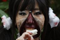 RNPS - REUTERS NEWS PICTURE SERVICE - PICTURES OF THE YEAR 2014 - ODDLY A participant in costume eats a sandwich after a Halloween parade in Kawasaki, south of Tokyo, in this October 26, 2014 file photo. REUTERS/Yuya Shino/Files (JAPAN - Tags: SOCIETY TPX IMAGES OF THE DAY)