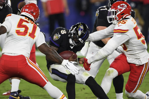 Baltimore Ravens quarterback Lamar Jackson (8) is hit by Kansas City Chiefs defensive ends Michael Danna (51) and Frank Clark (55) during the first half of an NFL football game Monday, Sept. 28, 2020, in Baltimore. (AP Photo/Nick Wass)