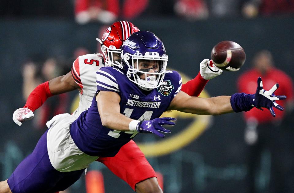 Northwestern Wildcats wide receiver Cam Johnson (14) stretches out as he tries to make a catch with Utah Utes cornerback Zemaiah Vaughn (5) defending as Utah and Northwestern play in the SRS Distribution Las Vegas Bowl at Allegiant Stadium on Saturday, Dec. 23, 2023. Northwestern won 14-7. | Scott G Winterton, Deseret News