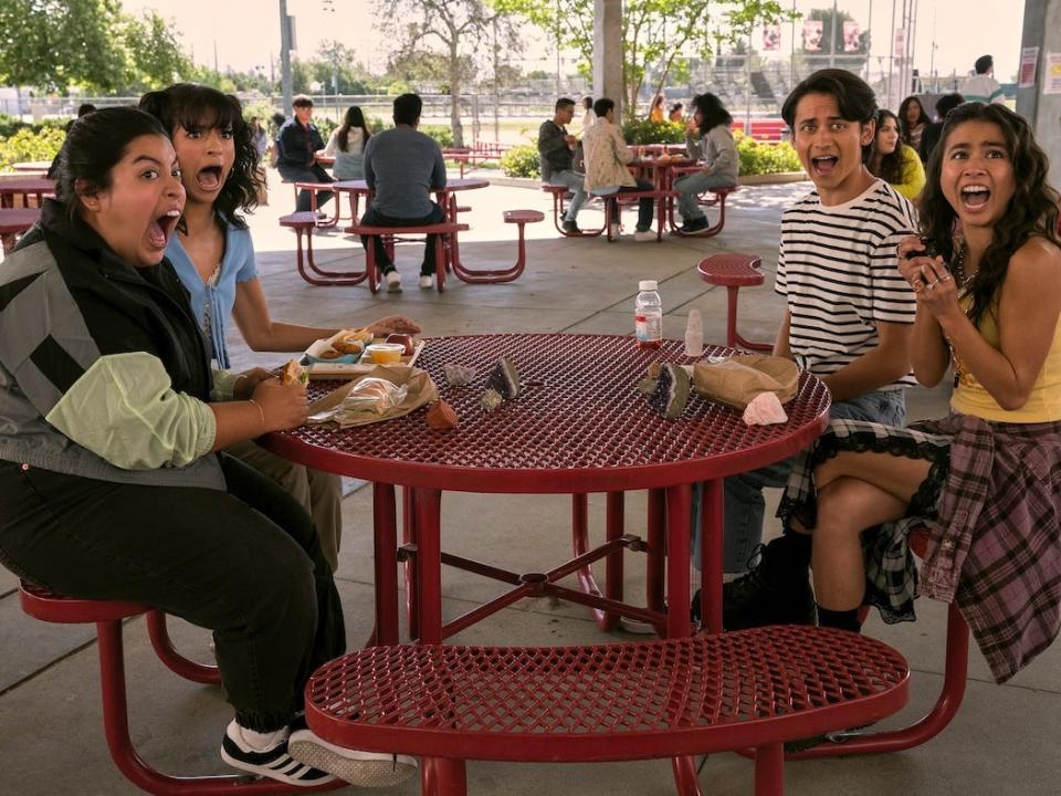 A table of four high school teens all screaming in surprise.