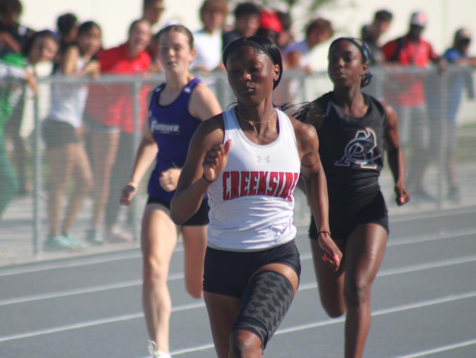 Janay Moorer of Creekside leads Shelby Jones of Fletcher and Ericka Tebakouna of Atlantic Coast in a heat of the girls 100-meter dash during the FHSAA District 2-4A high school track and field meet.