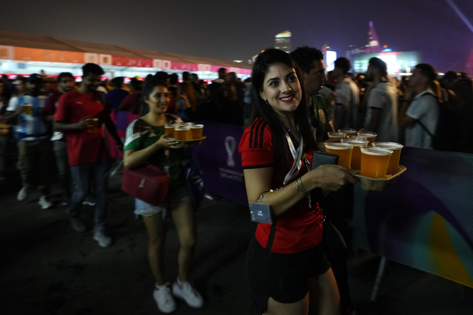 Fans carry their beers at a fan zone ahead of the FIFA World Cup, in Doha, Qatar Saturday, Nov. 19, 2022. (AP Photo/)