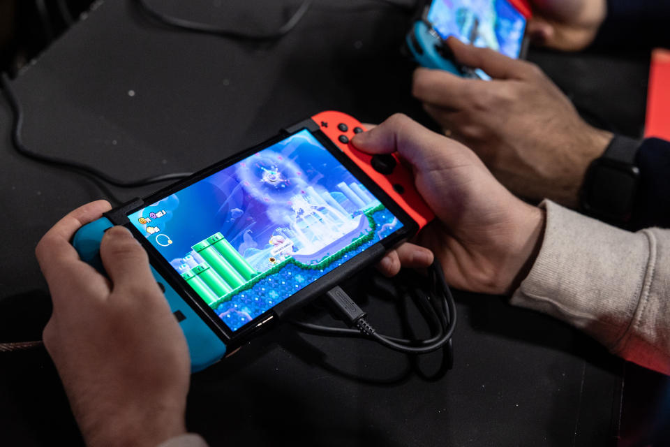 MILAN, ITALY - NOVEMBER 24: Two men use an Oled model Nintendo Switch gaming system while playing video games at the Japanese publisher Nintendo Switch's stand during Milan Games Week 2023 at Rho Fieramilano on November 24, 2023 in Milan, Italy. Milan Games Week is the most important video games festival in Italy, featuring the latest news of gaming industry, the most exciting esports tournaments and amazing digital entertainment moments. (Photo by Emanuele Cremaschi/Getty Images)