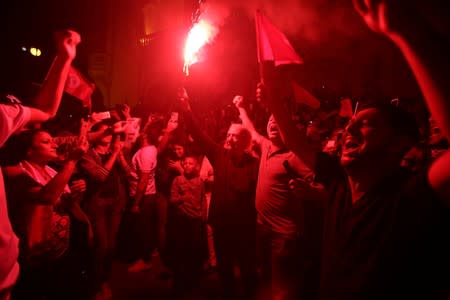 Supporters of Tunisian presidential candidate Kais Saied celebrate after unofficial results of the second round runoff of a presidential election in Tunis