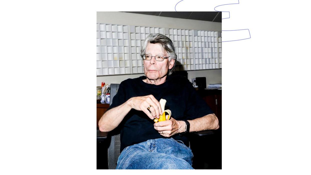 a man sitting in a chair holding a banana