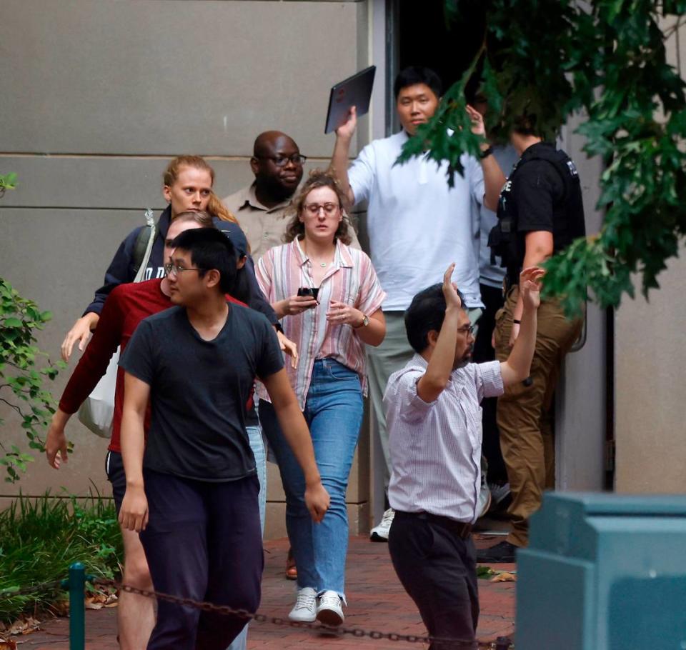 People walked out of a UNC-Chapel Hill building hands in the air as law enforcement responded to an “active assailant situation” on campus on Aug. 28, 2023. Professor Zijie Yan who was shot and killed on campus that day.