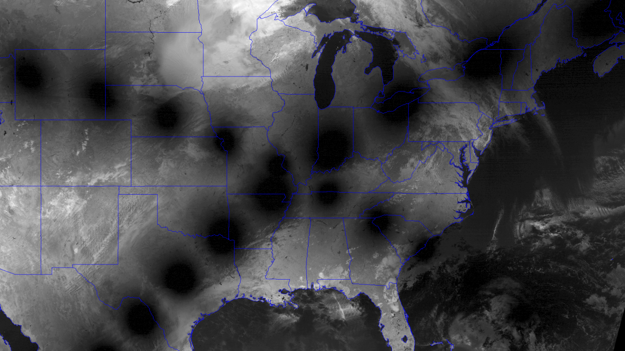  A satellite image of the US in black and white with the moon's shadow paths making a cross. 