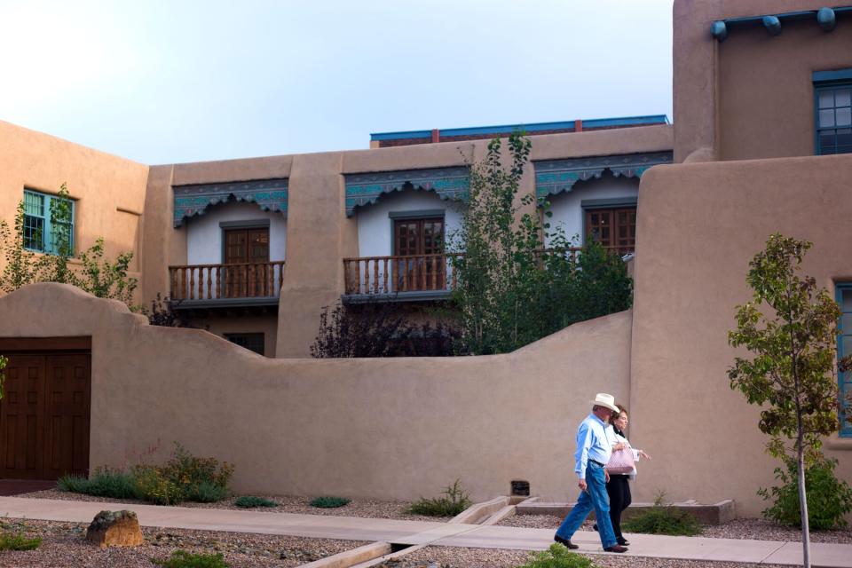 A senior couple walking past the newly renovated Santa Fe County Building in downtown Santa Fe at dusk.