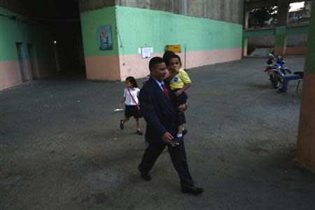 A man, who is on his way to work, walks through the lobby of the "Tower of David" skyscraper in Caracas February 5, 2014. REUTERS/Jorge Silva