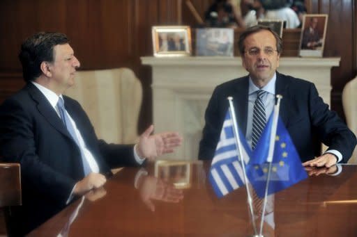 Greek Prime Minister Antonis Samaras (R) talks with European Commission President Jose Manuel Barroso during their meeting at the prime minister's office in Athens. Barroso urged Greece to deliver on its obligations to its creditors to remain in the eurozone