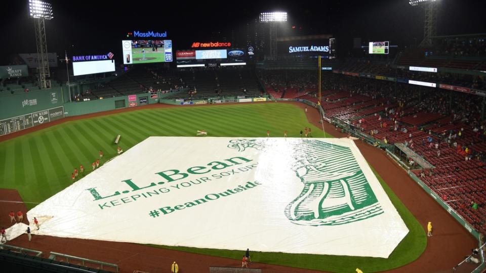 The Boston Red Sox grounds crew puts the tarp on the field during the fourth inning at Fenway Park.