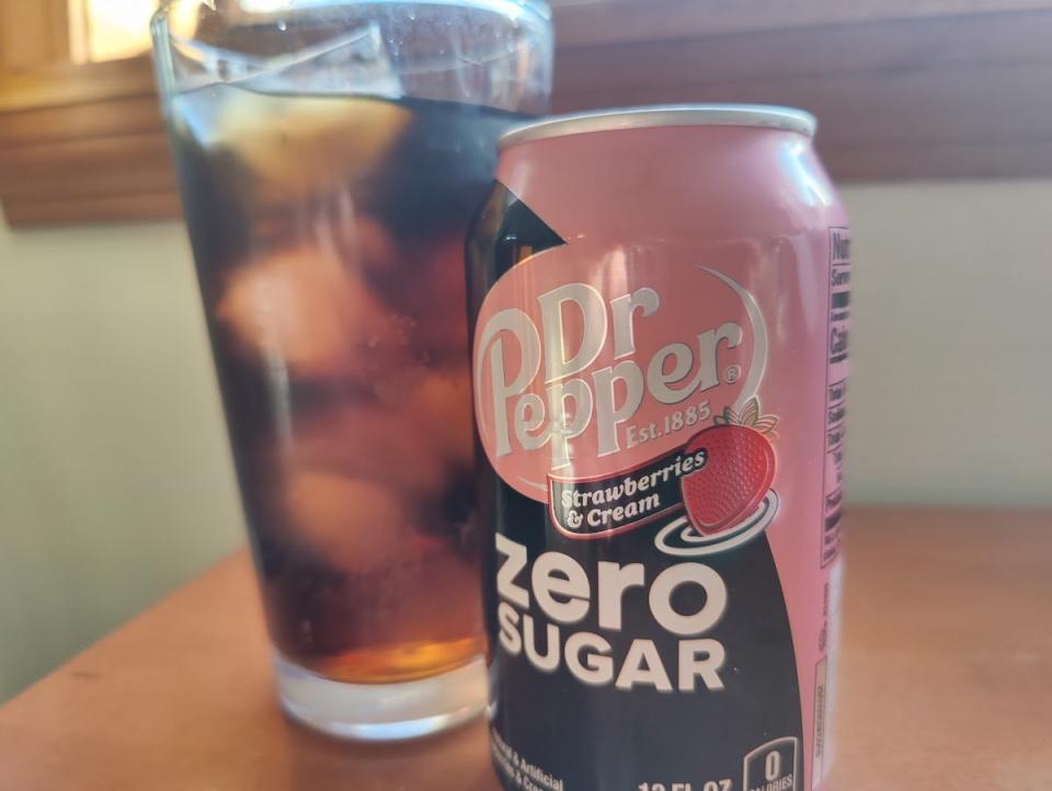 A can of Dr Pepper Strawberries & Cream Zero Sugar next to a glass of soda with ice