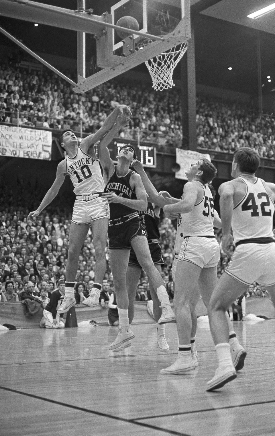 FILE - Kentucky's Louie Dampier (10) out-jumps Michigan's Jim Myers under the basket as the ball heads for the hoop during an NCAA college basketball Mid-East final game at Iowa City, March 12, 1966. (AP Photo/Larry Stoddard, File)