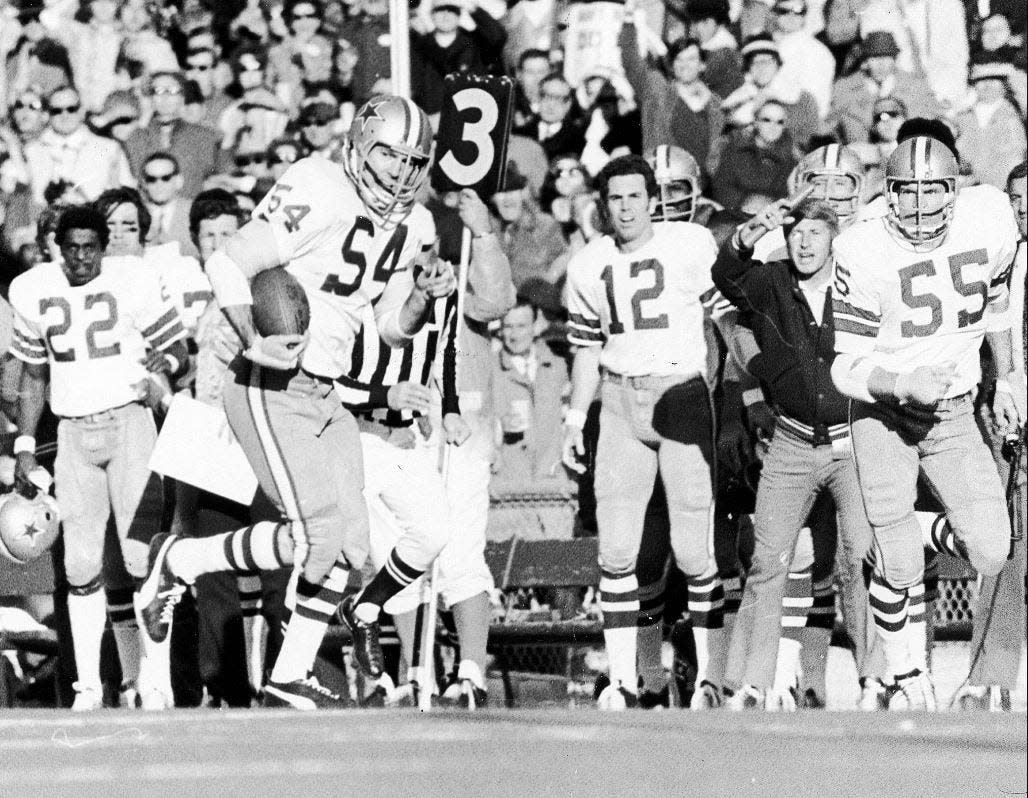 Cowboys linebacker Chuck Howley runs after intercepting Dolphins quarterback Bob Griese in the fourth quarter of Super Bowl VI. Watching from the sidelines are fellow Hall of Famers Bob Hayes (22) and Roger Staubach (12).