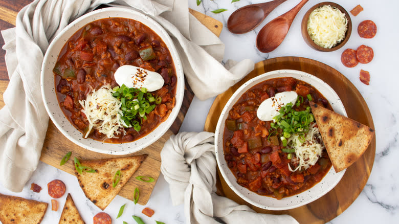 two garnished meat chili bowls