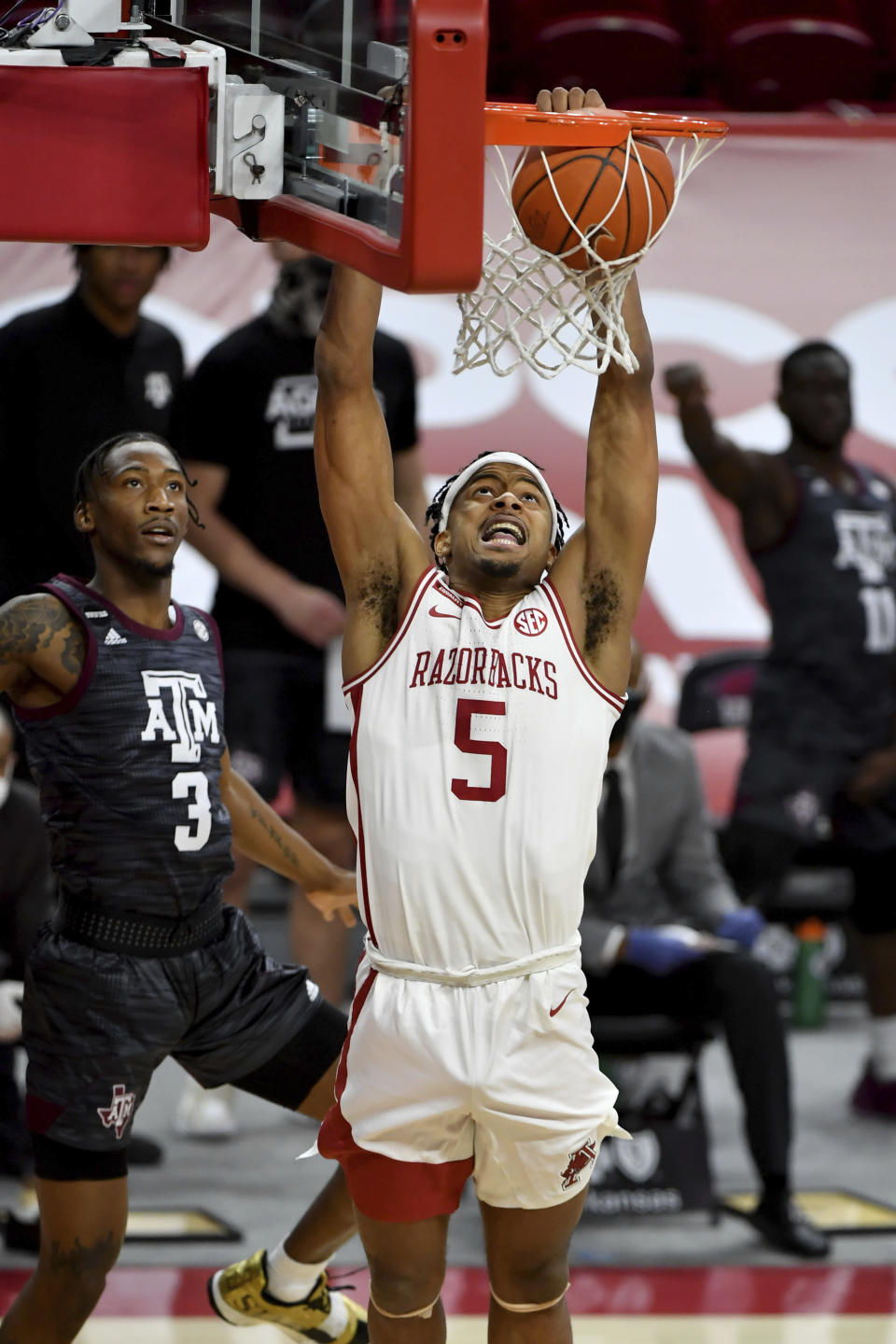 Arkansas guard Moses Moody (5) dunks the ball in front of Texas A&M defender Quenton Jackson (3) during the first half of an NCAA college basketball game in Fayetteville, Ark., Saturday, March 6, 2021. (AP Photo/Michael Woods)