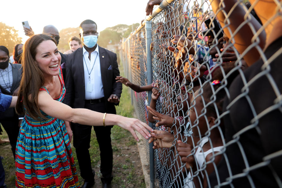 KINGSTON, JAMAICA â€“ MARCH 22: Catherine, Duchess of Cambridge shakes hands with children during a visit to Trench Town, the birthplace of reggae music, on day four of the Platinum Jubilee Royal Tour of the Caribbean on March 22, 2022 in Kingston, Jamaica. The Duke and Duchess of Cambridge are visiting Belize, Jamaica, and The Bahamas on their week-long tour. (Photo by Chris Jackson-Pool/Getty Images)