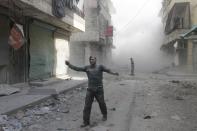 An injured man walks along a street after what activists said was a barrel bomb dropped by forces loyal to Syria's President Bashar al-Assad in Aleppo's al-Myassar neighbourhood April 16, 2014. REUTERS/Firas Badawi (SYRIA - Tags: POLITICS CIVIL UNREST CONFLICT TPX IMAGES OF THE DAY)