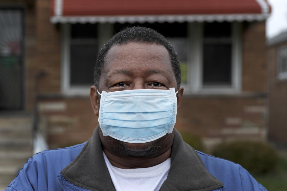 Anthony Travis, who has recovered from COVID-19 and lives with his sister and adult daughter, poses for a portrait outside his Riverdale, Ill., home on Thursday, April 23, 2020. Travis, who's diabetic, has high blood pressure and is a cancer survivor, must self isolate within the home as a matter of taking care of one another. When his daughter got pneumonia: He could hear her through the walls. “I have to, as a parent, sit up and listen to my child go through pain and agony and suffering because of not being able to breathe,” he said. “I couldn’t give her comfort, other than with my words.” (AP Photo/Charles Rex Arbogast)