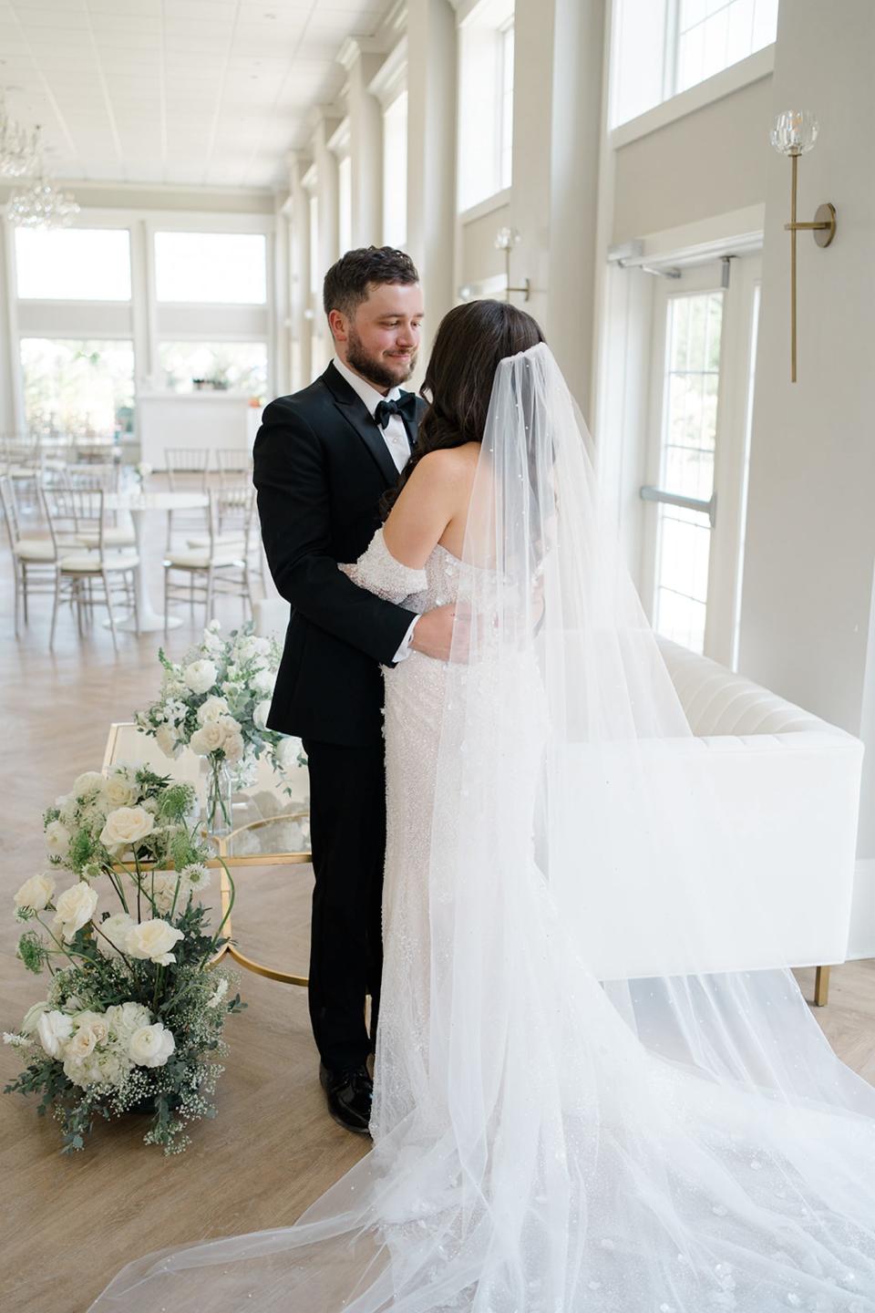 A bride and groom embrace at their wedding.