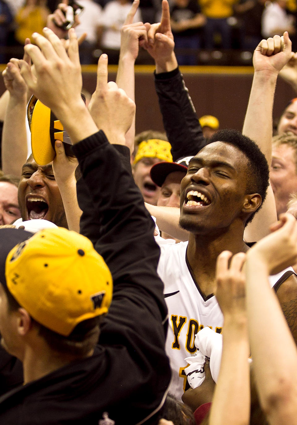Univeristy of Wyoming forward Derek Cooke Jr. celebrates with fans after they rushed the floor prior to the Cowboys defeating San Diego State at the Arena- Auditorium in Laramie, Wyo. (AP Photo/Jeremy Martin)