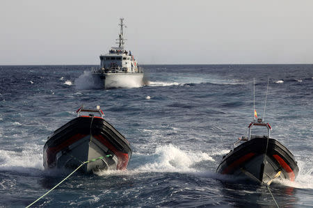 A Libyan coast guard vessel chases away former fishing trawler Golf Azzurro of the Proactiva Open Arms rescue charity in the Western Mediterranean Sea August 15, 2017. REUTERS/Yannis Behrakis