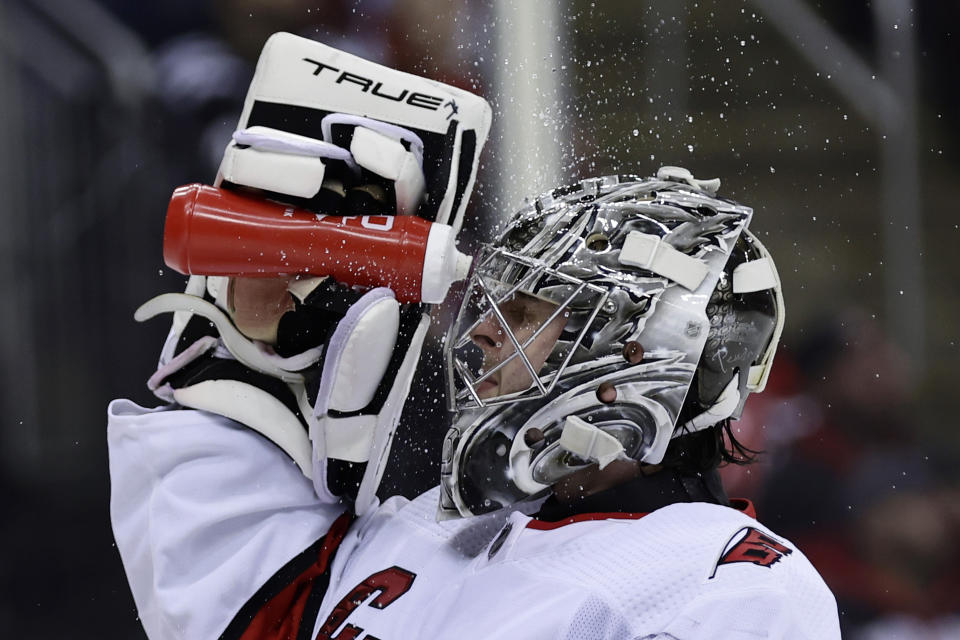 Carolina Hurricanes goaltender Pyotr Kochetkov sprays his face with water during the second period of an NHL hockey game against the New Jersey Devils, Sunday, March 12, 2023, in Newark, N.J. (AP Photo/Adam Hunger)