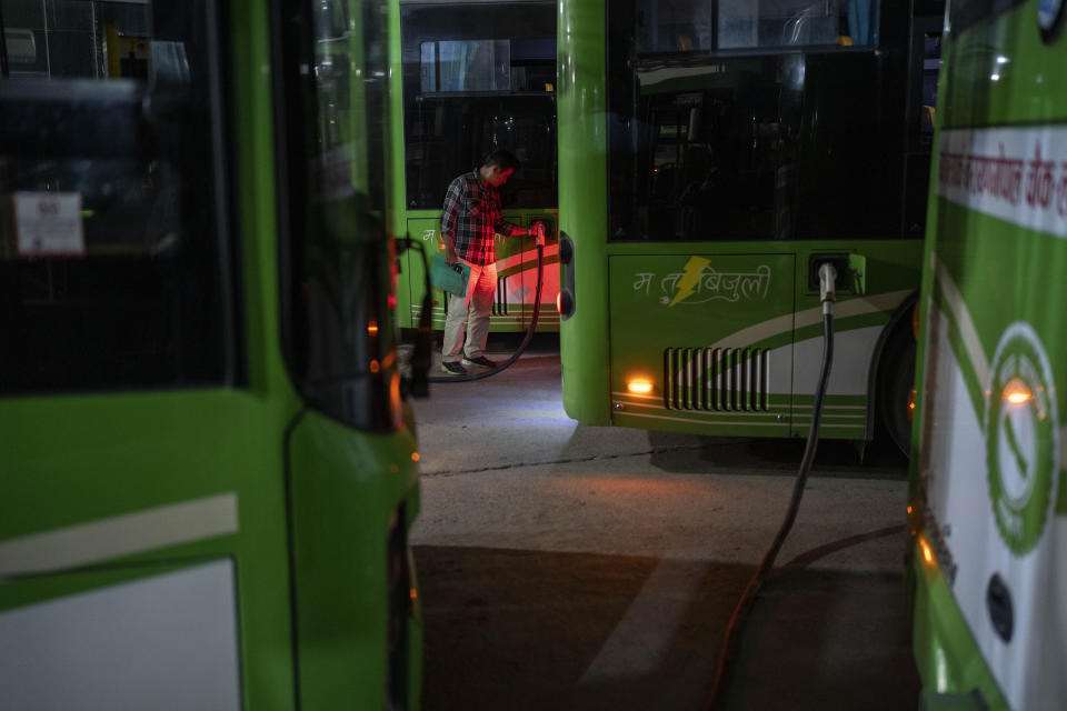 A worker at an electric charging station recharges the batteries of a public transport bus in Kathmandu, Nepal, Friday, May 10, 2024. Nearly all of the electricity produced in Nepal is clean energy, most of it generated by river-fed hydro-electricity. Thanks to that abundant source of power, the country is quickly expanding charging networks and imports of EVs have doubled in each of the past two years, according to customs data. (AP Photo/Niranjan Shrestha)